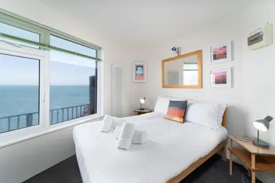 a bedroom with a bed and a large window at The Lighthouse in St Ives