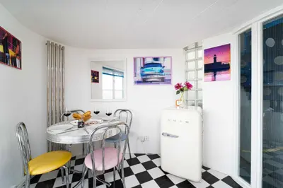 a kitchen with a table and chairs and a refrigerator at The Lighthouse in St Ives