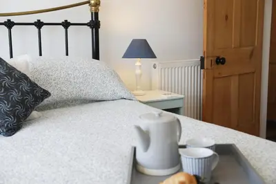 a bedroom with a bed with a black and white bedspread at Stowaway, Port Isaac Bay Holidays in Port Isaac