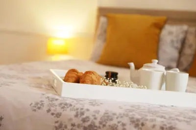 a white tray of pastries on a bed at Tamarisk, Port Isaac Bay Holidays in Port Isaac