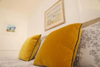 two yellow pillows on a bed in a room at Tamarisk, Port Isaac Bay Holidays in Port Isaac