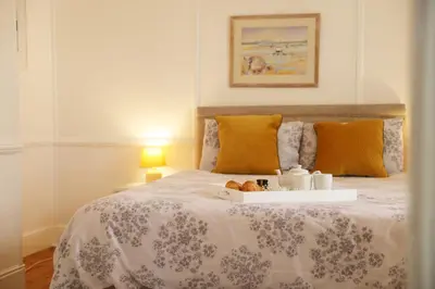 a bedroom with a bed with a tray of food on it at Tamarisk, Port Isaac Bay Holidays in Port Isaac