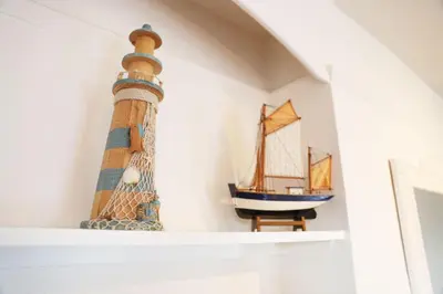 a lighthouse on a shelf with a toy boat on it at Tamarisk, Port Isaac Bay Holidays in Port Isaac