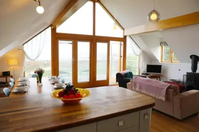 a living room with a table with a bowl of fruit on it at Northlight, Port Isaac Bay Holidays in Port Isaac