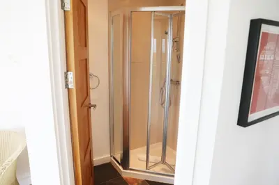 a shower in a bathroom with a glass door at Northlight, Port Isaac Bay Holidays in Port Isaac