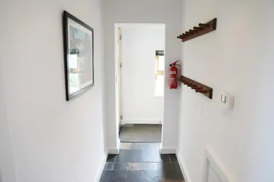 a hallway with white walls and a white door at Northlight, Port Isaac Bay Holidays in Port Isaac