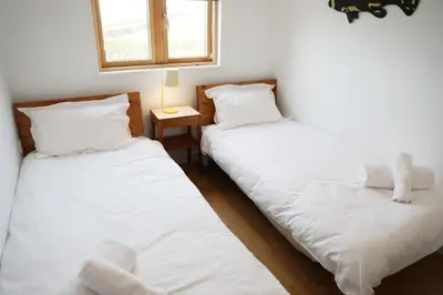 two beds sitting next to each other in a room at Northlight, Port Isaac Bay Holidays in Port Isaac