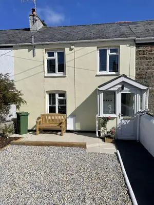 a house with a bench in front of it at The Little Seahorse - Newly Renovated Cottage 5mins Walk The Beach with Hot Tub in Tywardreath