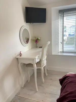 a white desk with a mirror and a white chair at The Little Seahorse - Newly Renovated Cottage 5mins Walk The Beach with Hot Tub in Tywardreath