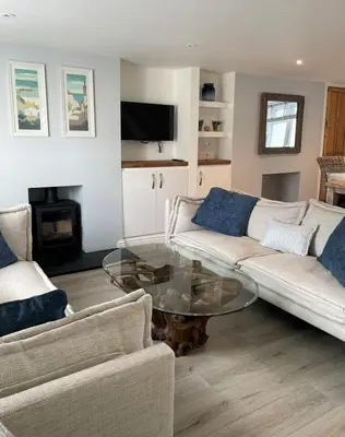 a living room with a couch and a glass table at The Little Seahorse - Newly Renovated Cottage 5mins Walk The Beach with Hot Tub in Tywardreath