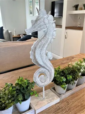 a white metal seahorse statue sitting on a table at The Little Seahorse - Newly Renovated Cottage 5mins Walk The Beach with Hot Tub in Tywardreath