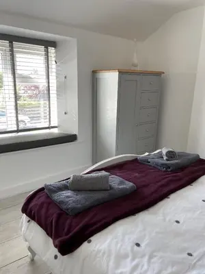 a bedroom with a large bed with towels on it at The Little Seahorse - Newly Renovated Cottage 5mins Walk The Beach with Hot Tub in Tywardreath