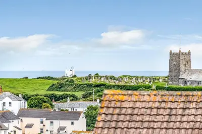 a view of a town with houses and a castle at Eveley Cottage in Boscastle