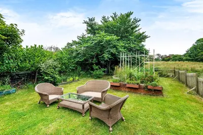 three chairs and a coffee table in a yard at Eveley Cottage in Boscastle