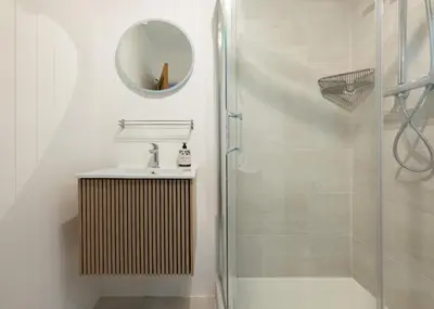 a bathroom with a shower and a sink and a mirror at Westward 8 in Polzeath