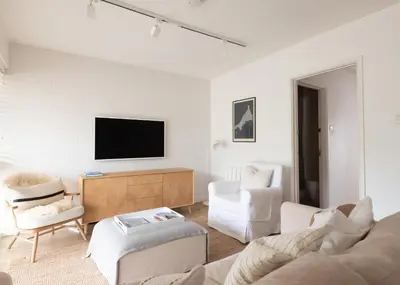 a living room with a couch and chairs and a tv at Westward 8 in Polzeath