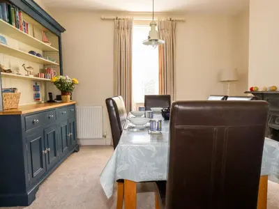 a dining room with a table and chairs at Driftwood in Fowey