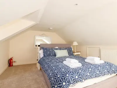a bedroom with a bed with two pillows on it at Driftwood in Fowey