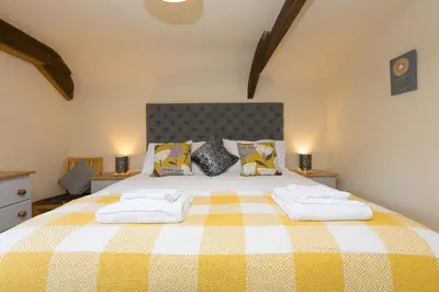 a bedroom with a large bed with two towels at FurnessThe West Dry in St Austell