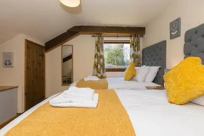 a bedroom with two beds with towels on them at FurnessThe West Dry in St Austell
