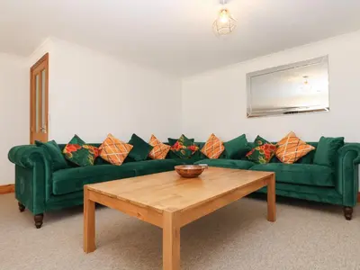 a living room with a green couch and a wooden coffee table at FurnessThe West Dry in St Austell