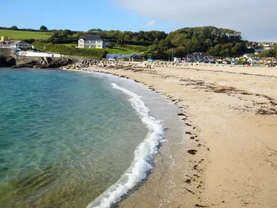 a beach with a group of people walking on the sand at Hazel Cottage in Budock Water