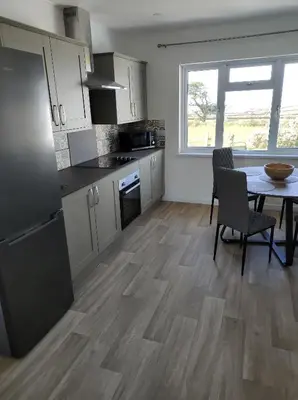 a kitchen with a table and a dining room at Trevose, sea views in Port Isaac