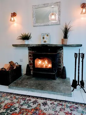 a fireplace in a living room with a fire place at Trevose, sea views in Port Isaac