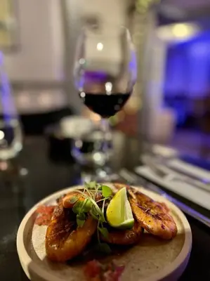a plate of food with shrimp and a glass of wine at Lobster Cove, Excellent location, Close to beach & coastal walks, Family run in Port Isaac