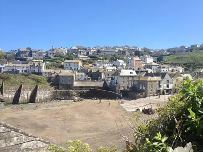 a group of people on a beach in front of a city at Lobster Cove, Excellent location, Close to beach & coastal walks, Family run in Port Isaac