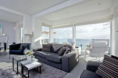 a living room with a couch and chairs and a large window at Spindrift - Hot Tub - Free WiFi - Free Parking - Pet Friendly in Praa Sands