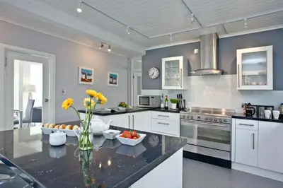 a kitchen with a table with a vase of flowers at Spindrift - Hot Tub - Free WiFi - Free Parking - Pet Friendly in Praa Sands