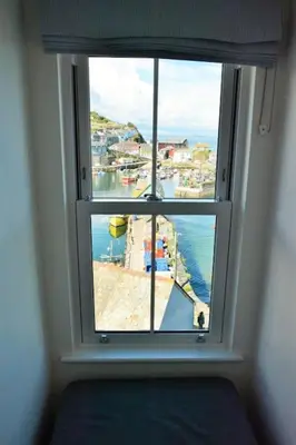 a window in a room with a view of the ocean at Fabulous 2 Bed Cottage - Outstanding Sea Views in Mevagissey