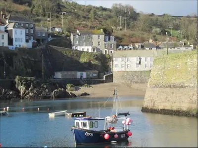 a small boat in a body of water at Fabulous 2 Bed Cottage - Outstanding Sea Views in Mevagissey