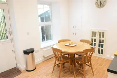 a dining room with a wooden table and chairs at Fabulous 2 Bed Cottage - Outstanding Sea Views in Mevagissey