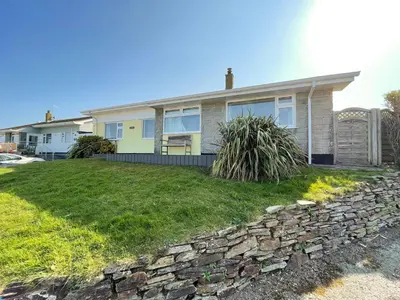 a house with a stone wall in front of it at Sunnybank, Port Isaac Bay Holidays in Port Isaac