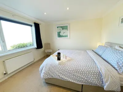 a bedroom with a bed and a table in it at Sunnybank, Port Isaac Bay Holidays in Port Isaac