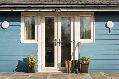 a blue house with a white door and windows at The Hut in Bodmin