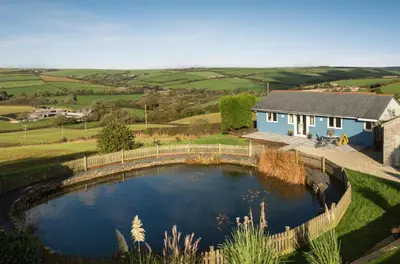 a house with a pond in the middle of a yard at The Hut in Bodmin