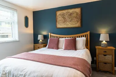 a bedroom with a bed with a blue wall at Finest Retreats - Tinners Rest in St Austell
