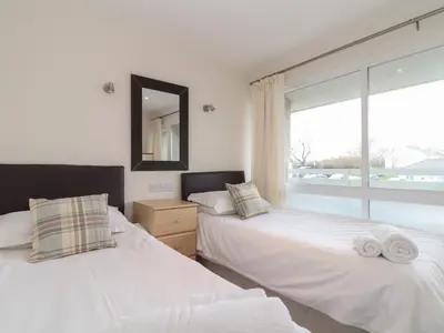two beds in a room with a window at 24 Atlantic Reach in Newquay