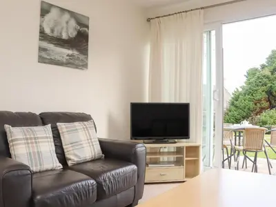 a living room with a couch and a flat screen tv at 24 Atlantic Reach in Newquay