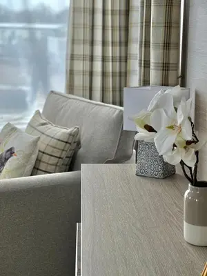 a vase of flowers on a table next to a couch at Summer Breeze @ Seven Bays, Padstow in Padstow