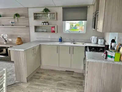 a kitchen with white cabinets and a sink at Summer Breeze @ Seven Bays, Padstow in Padstow