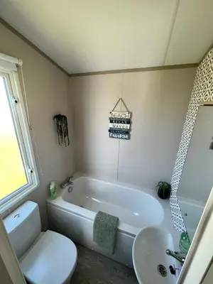 a bathroom with a tub and a toilet and a sink at Summer Breeze @ Seven Bays, Padstow in Padstow