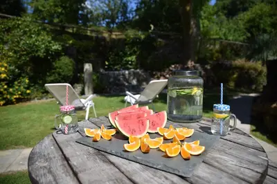 a cutting board with slices of fruit on a table at Ta Mill Holiday Cottages & Lodges - Forge Cottage in Launceston