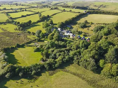 an aerial view of a farm with fields and trees at Ta Mill Holiday Cottages & Lodges - Forge Cottage in Launceston