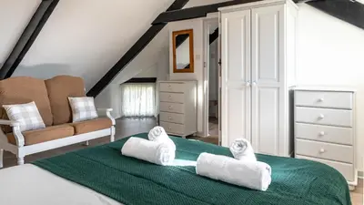 a bedroom with a bed with towels on it at Ta Mill Holiday Cottages & Lodges - Forge Cottage in Launceston