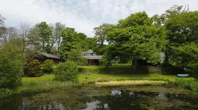 a house and a pond in front of a house at Ta Mill Holiday Cottages & Lodges -Ta Mill House in Launceston
