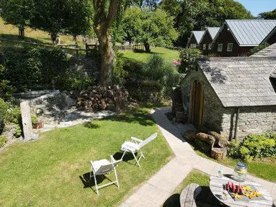 an aerial view of a garden with two chairs and a building at Ta Mill Holiday Cottages & Lodges -Ta Mill House in Launceston